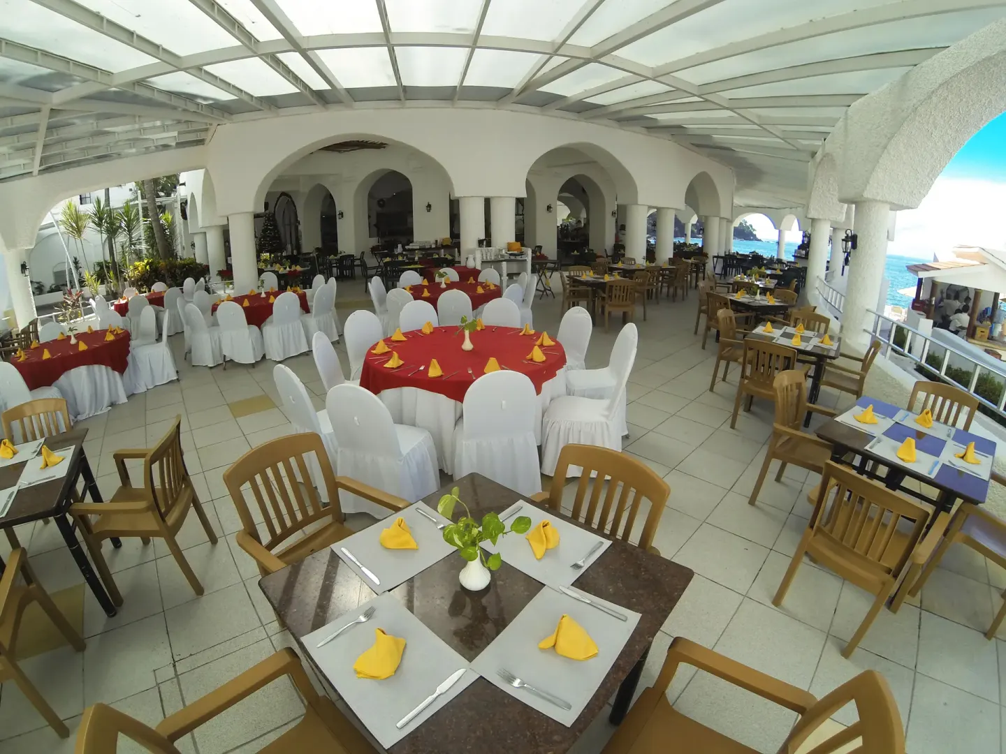 Covered terrace set with round banquet tables and ocean views at Tesoro Manzanillo.