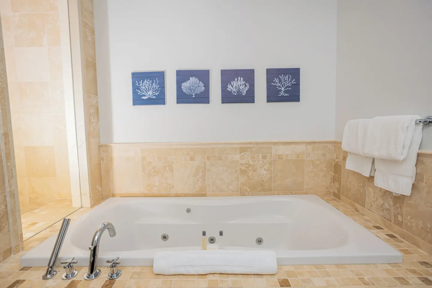 Bathroom soaking tub with wall art and towels at The Atrium Resort.