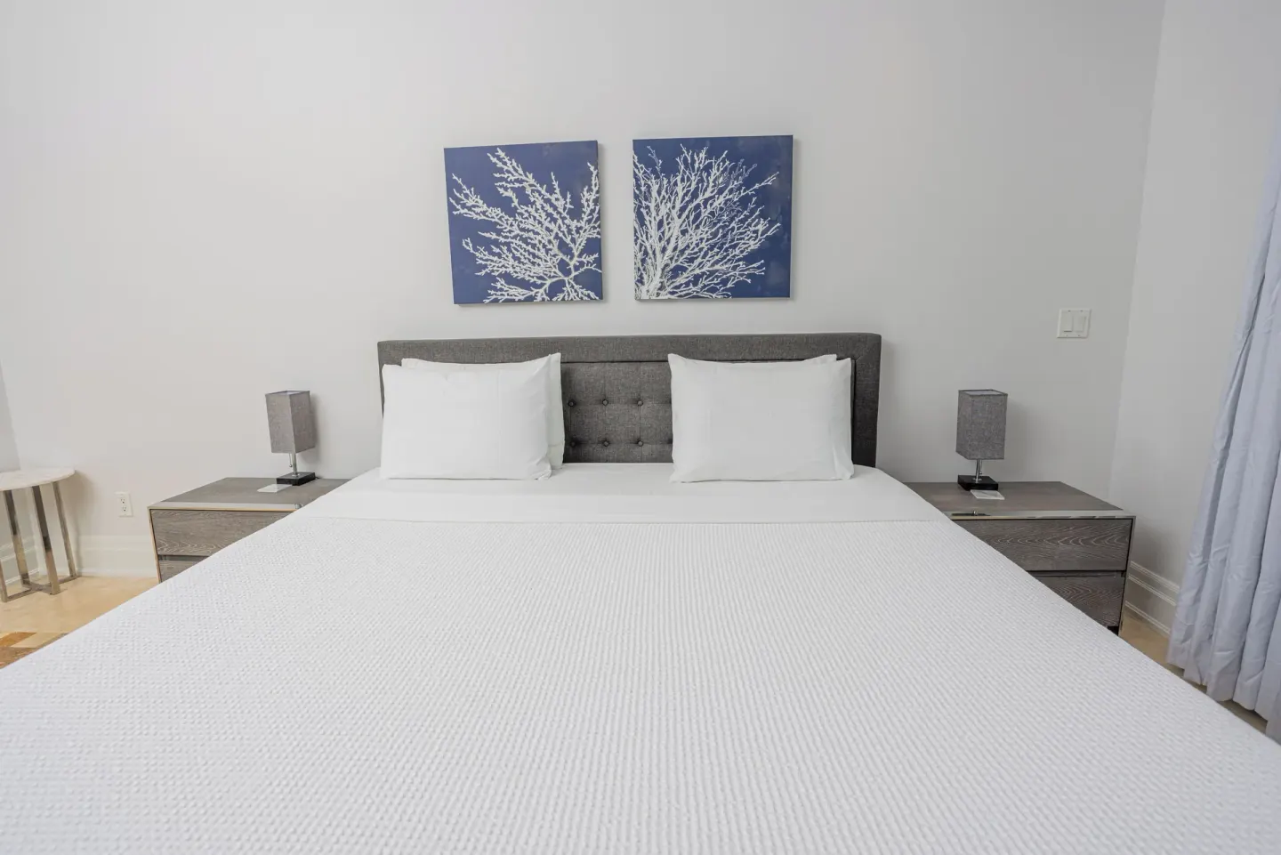 King bed with nightstands and blue wall art at The Atrium Resort.