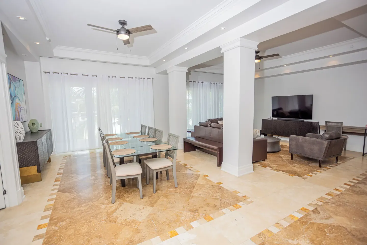 Open dining and living area with glass table and sofas at The Atrium Resort.