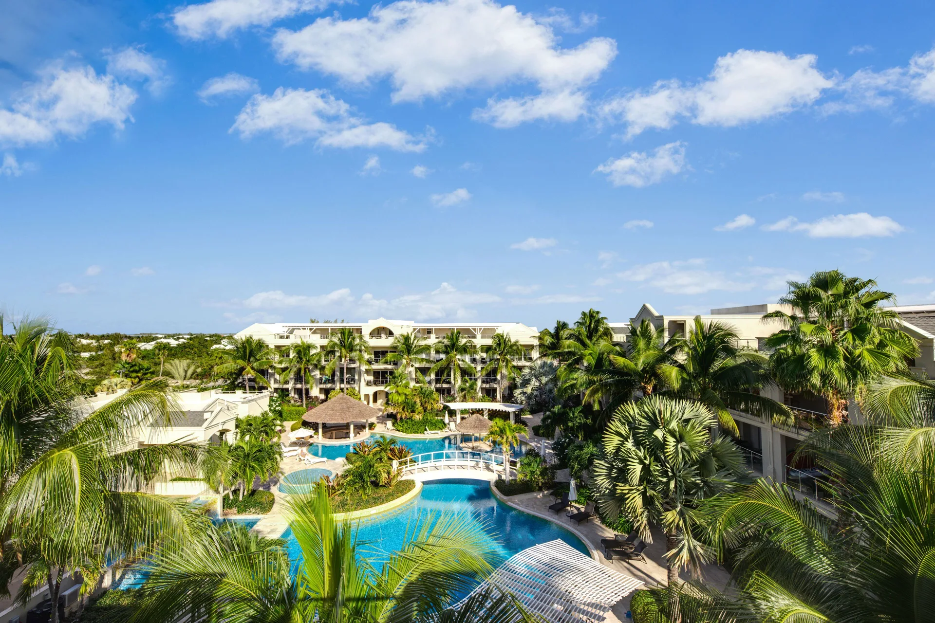 Elevated daytime view of the pool courtyard and palm trees at The Atrium Resort.
