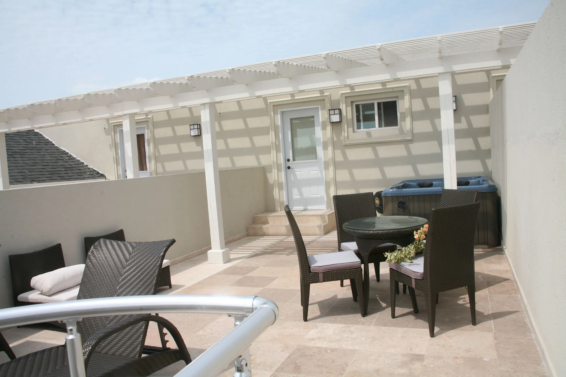 Private terrace with lounge chairs, dining set and hot tub at The Atrium Resort.