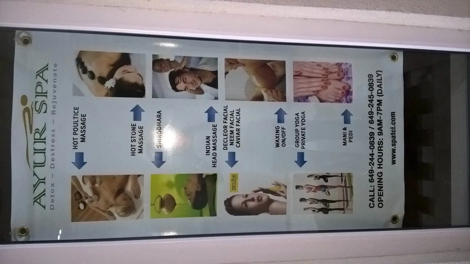 A spa services poster mounted in a window at The Atrium Resort.