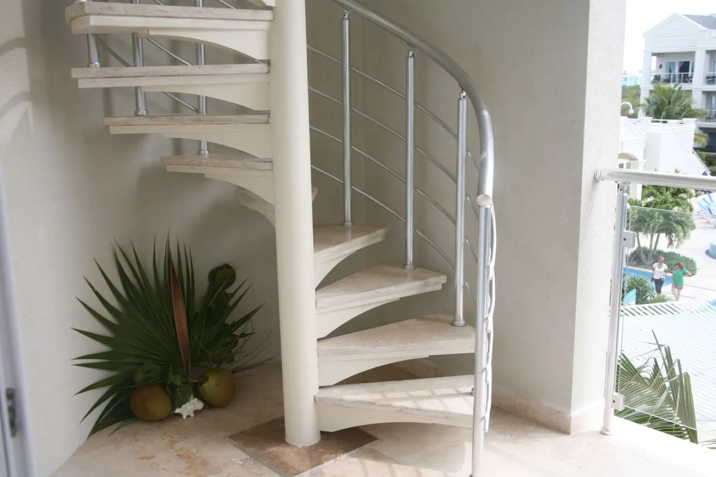 Balcony spiral staircase with metal railing and plants at the 3 Bedroom Penthouse at The Atrium Resort.
