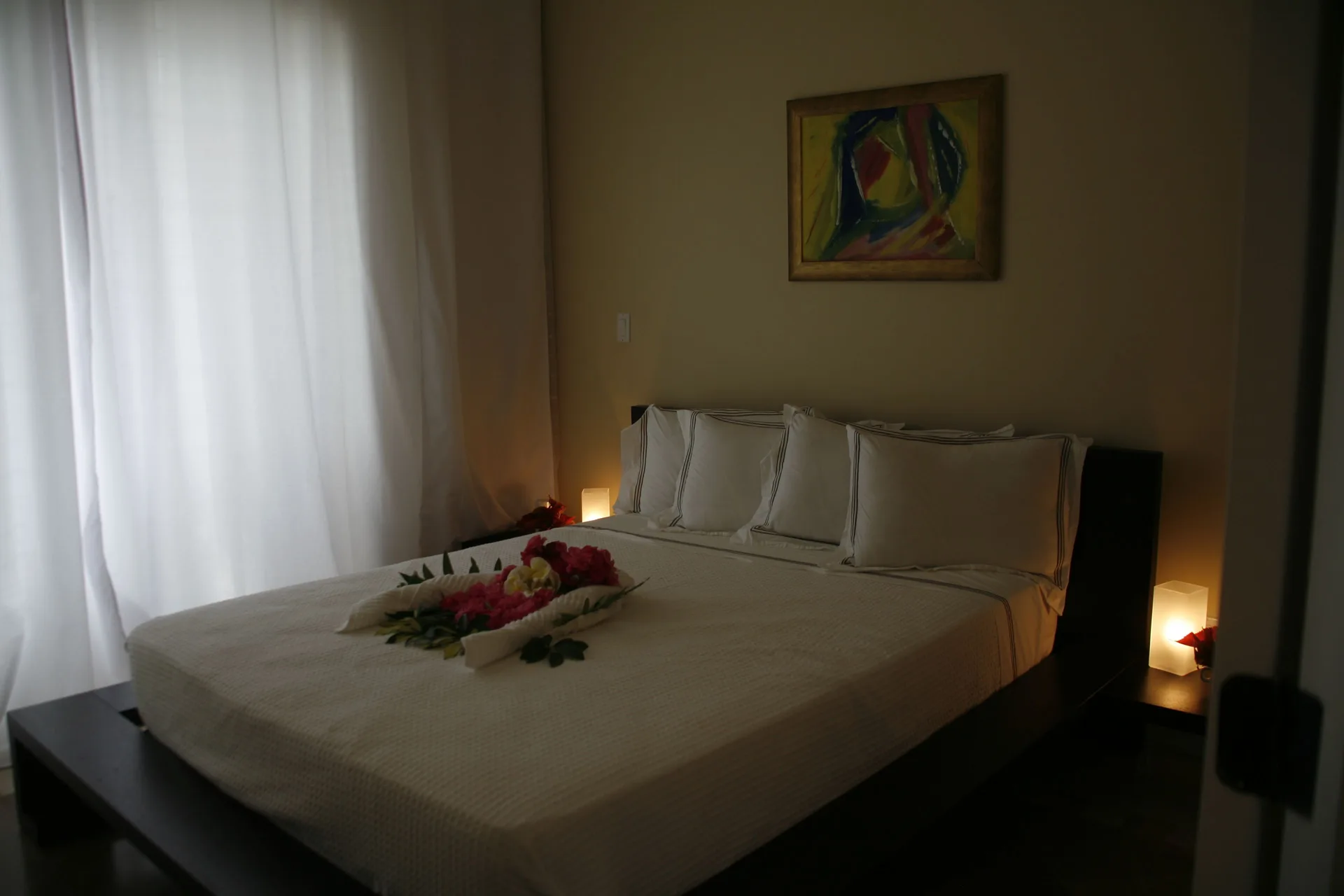 Bedroom with king bed and floral towel display in the 3 Bedroom Penthouse at The Atrium Resort.