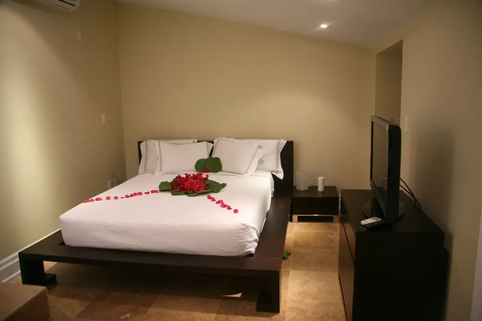 Bedroom with king bed, TV, and red petal decor in the 3 Bedroom Penthouse at The Atrium Resort.
