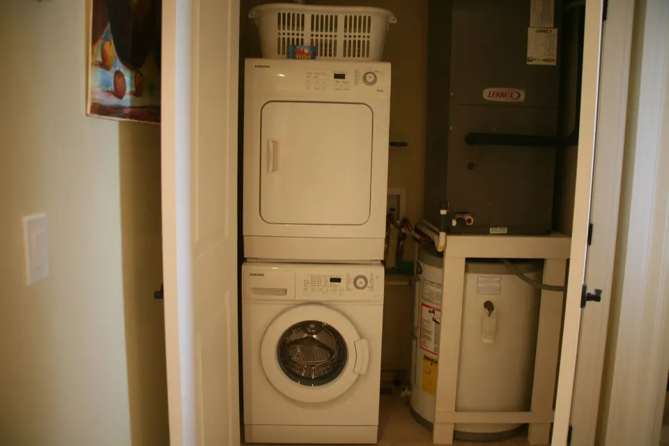 Laundry closet with stacked washer and dryer in the 3 Bedroom Penthouse at The Atrium Resort.
