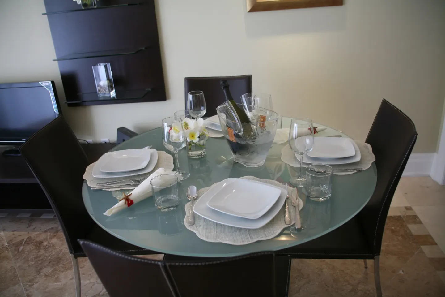 Glass dining table set for four in a two-bedroom condo at The Atrium Resort.