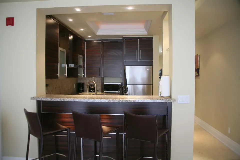 Kitchen pass-through with bar stools in a two-bedroom condo at The Atrium Resort.