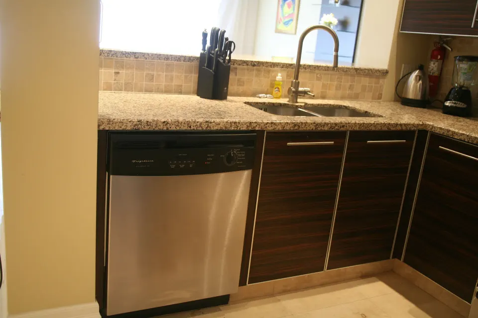 Kitchen sink, dishwasher, and countertop in a condo at The Atrium Resort.