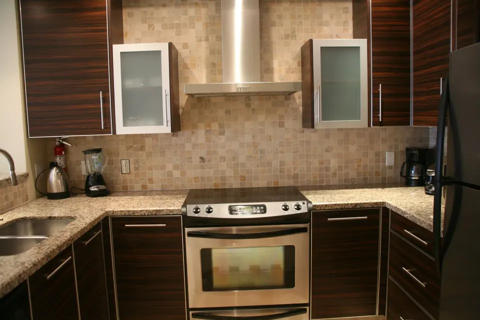 Full kitchen with range, hood, and dark cabinetry in a condo at The Atrium Resort.