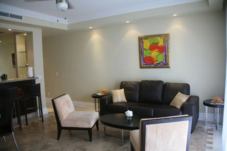Living room with black sofa and chairs in a condo at The Atrium Resort.