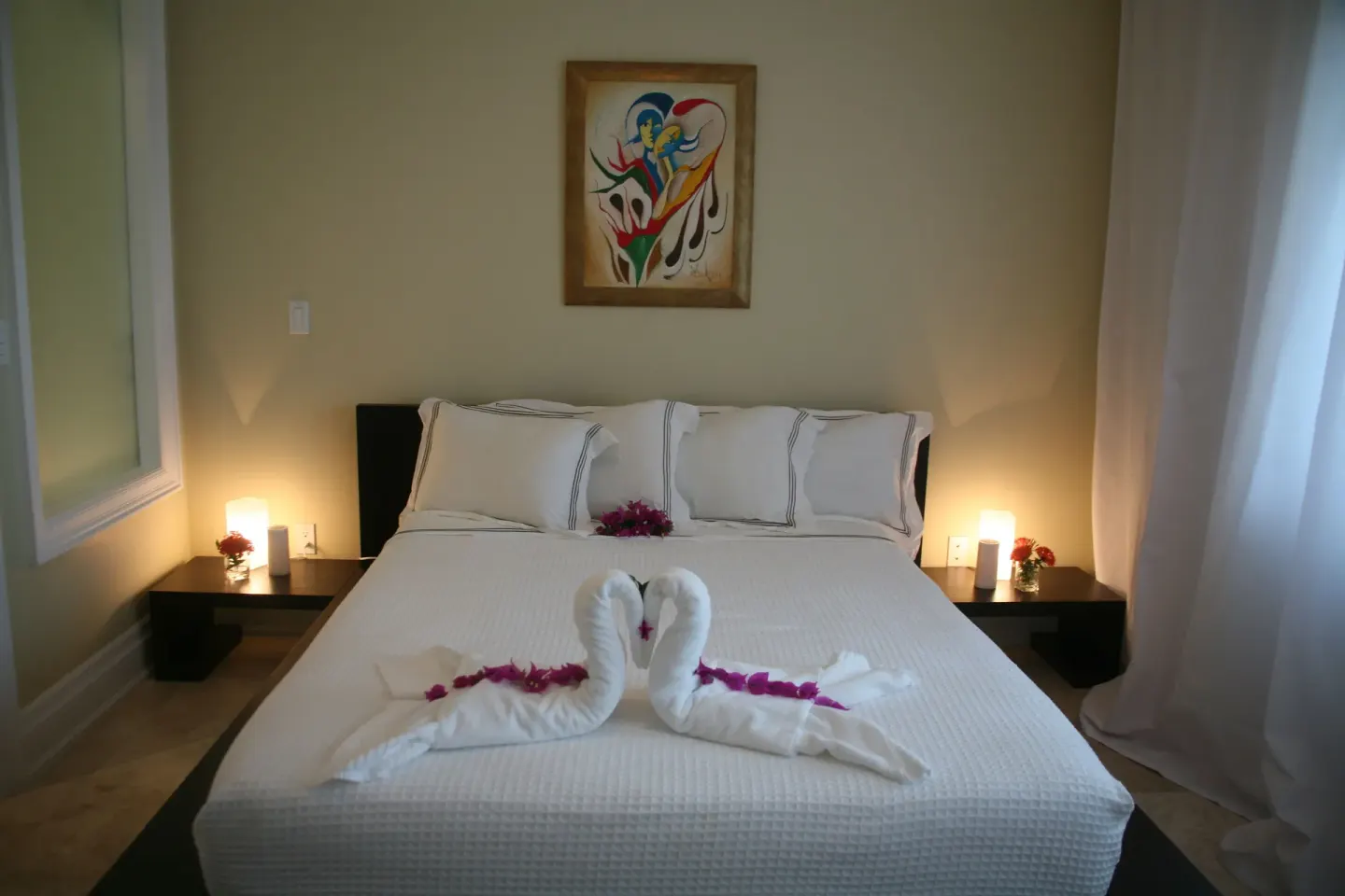 One Bedroom Condo bed with towel swans and flowers at The Atrium Resort.