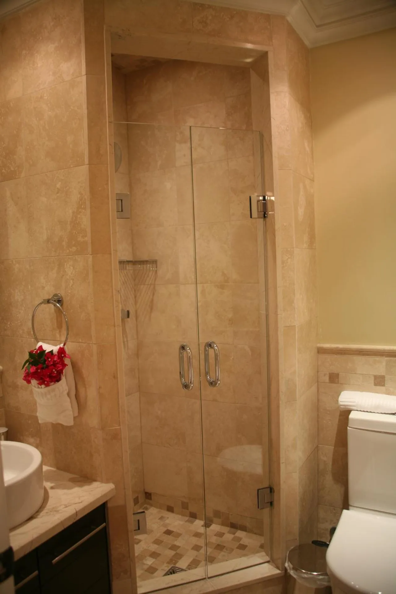 Studio bathroom with glass shower, tiled walls, sink, and toilet at The Atrium Resort.