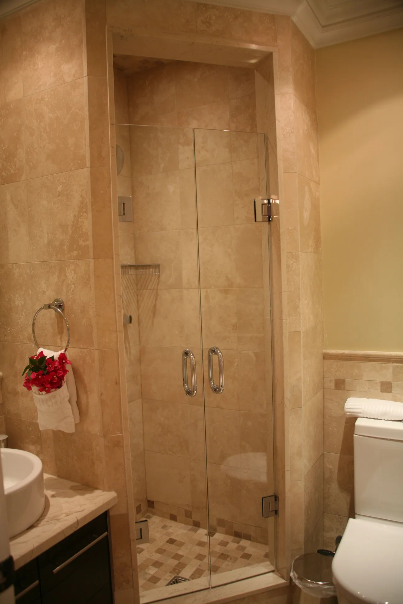 Studio bathroom shower and toilet with beige tile at The Atrium Resort.