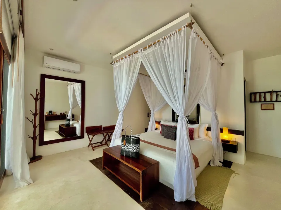 Bright bedroom with a canopy bed and simple white decor at The Beach Tulum