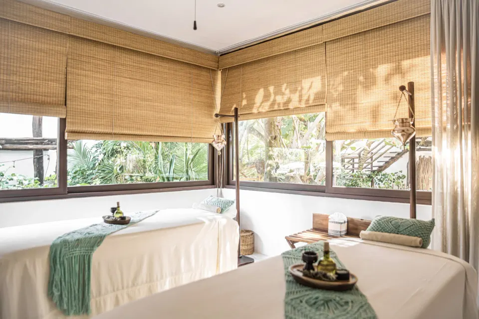Bright spa treatment room with two massage tables at The Beach Tulum