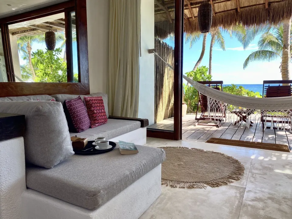 Guest room seating area with a hammock and ocean view at The Beach Tulum