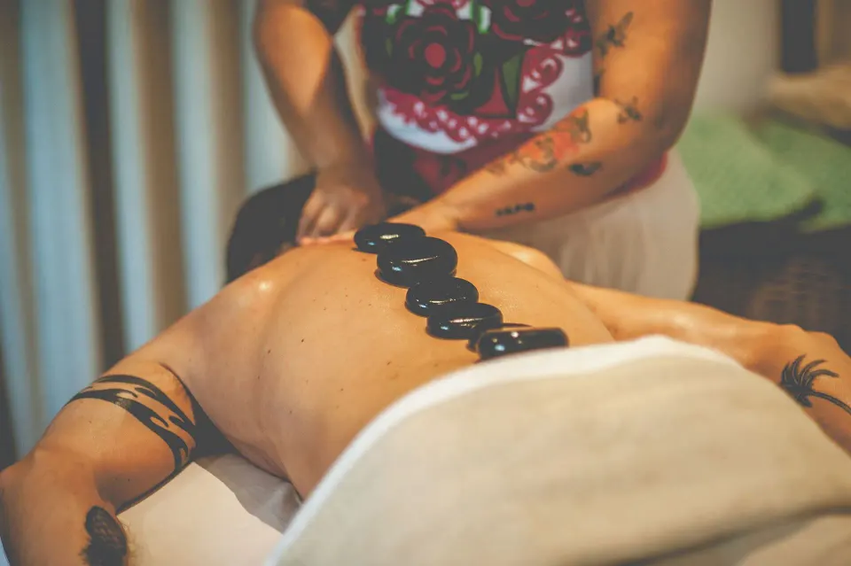Close-up of hot stones placed along a guest's back at The Beach Tulum