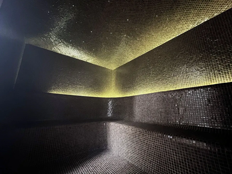 Dimly lit tiled steam room interior in the spa at The Beach Tulum