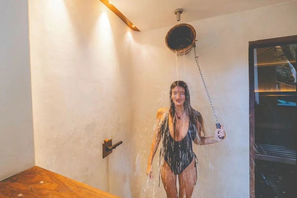Person using an overhead shower in a tiled spa shower at The Beach Tulum