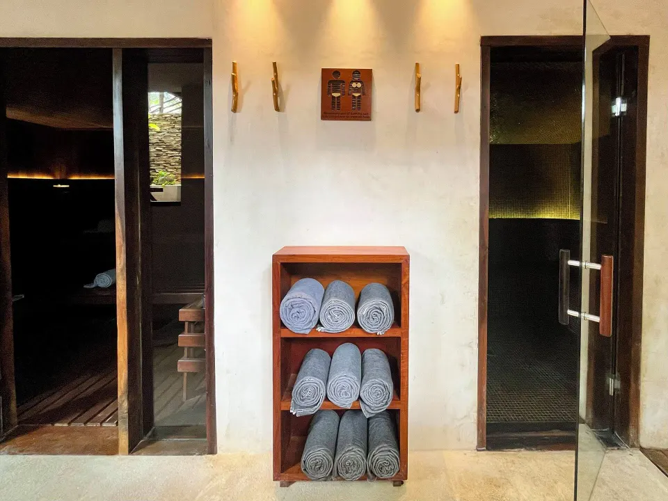 Towel rack and two wooden sauna doors in the spa at The Beach Tulum