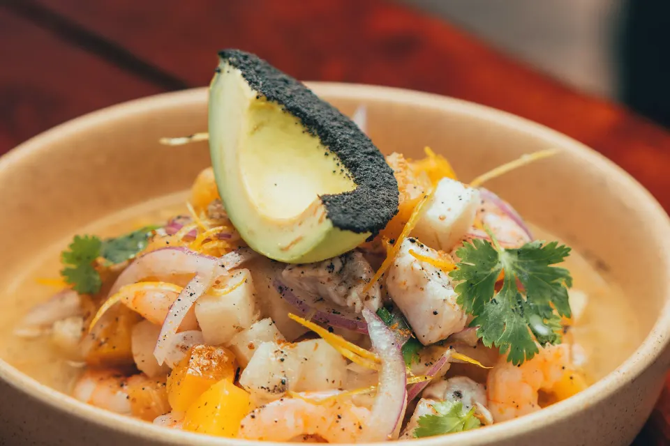 Bowl of ceviche with avocado garnish at The Beach Tulum