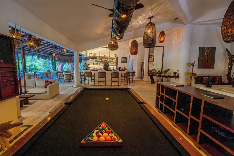 Indoor bar area with a pool table in the foreground at The Beach Tulum