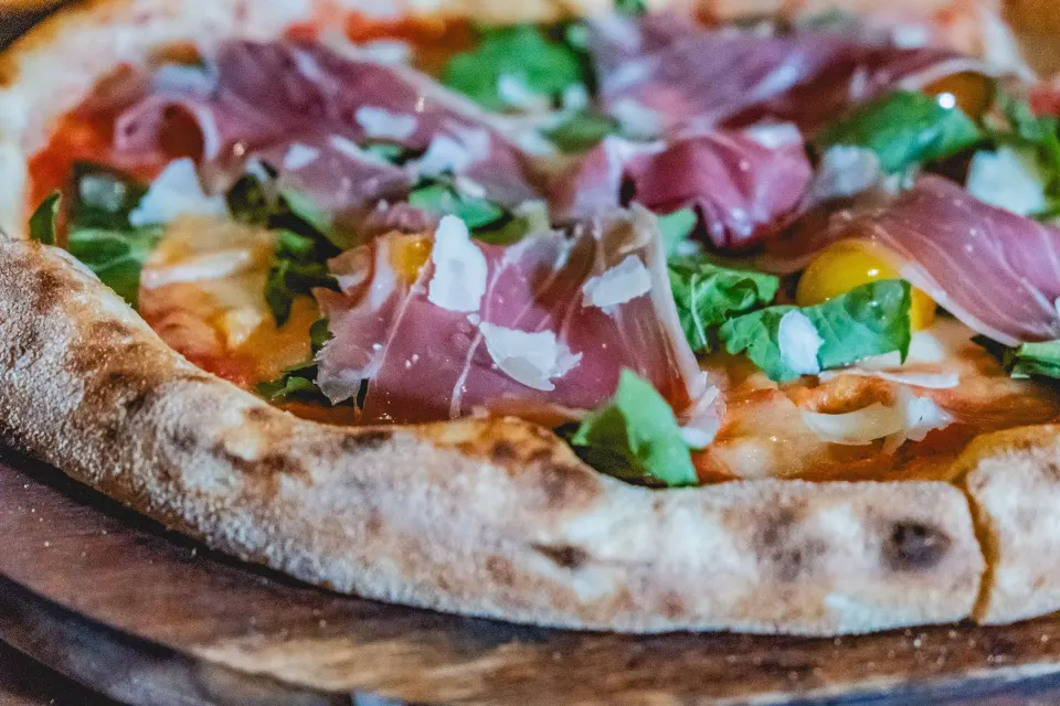 Close-up of a prosciutto and arugula pizza at The Beach Tulum