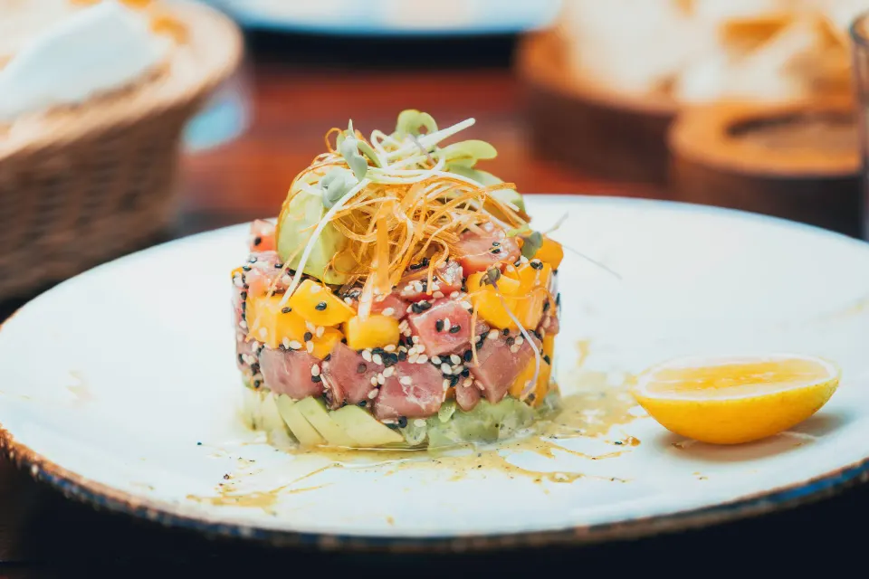 Fresh tuna and mango tartare served on a white plate at The Beach Tulum