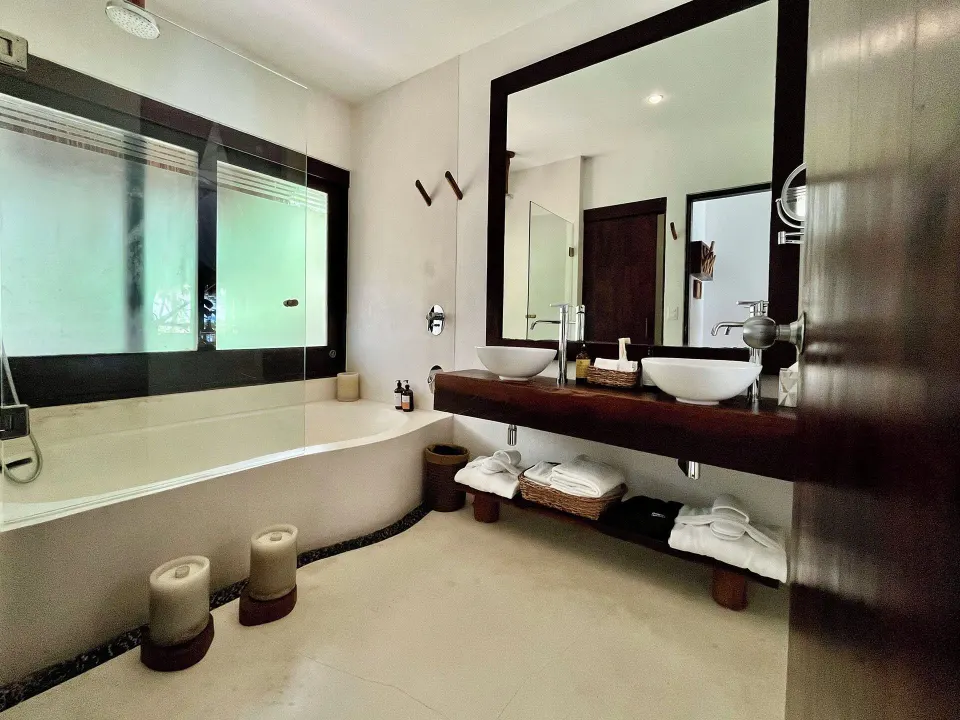 Bathtub with showerhead and double vanity in a Beachfront Rooftop room at The Beach Tulum