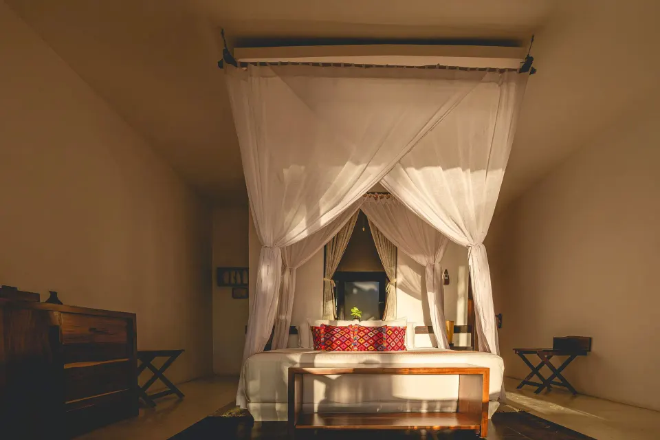 Canopy bed with mosquito netting in bedroom at The Beach Tulum