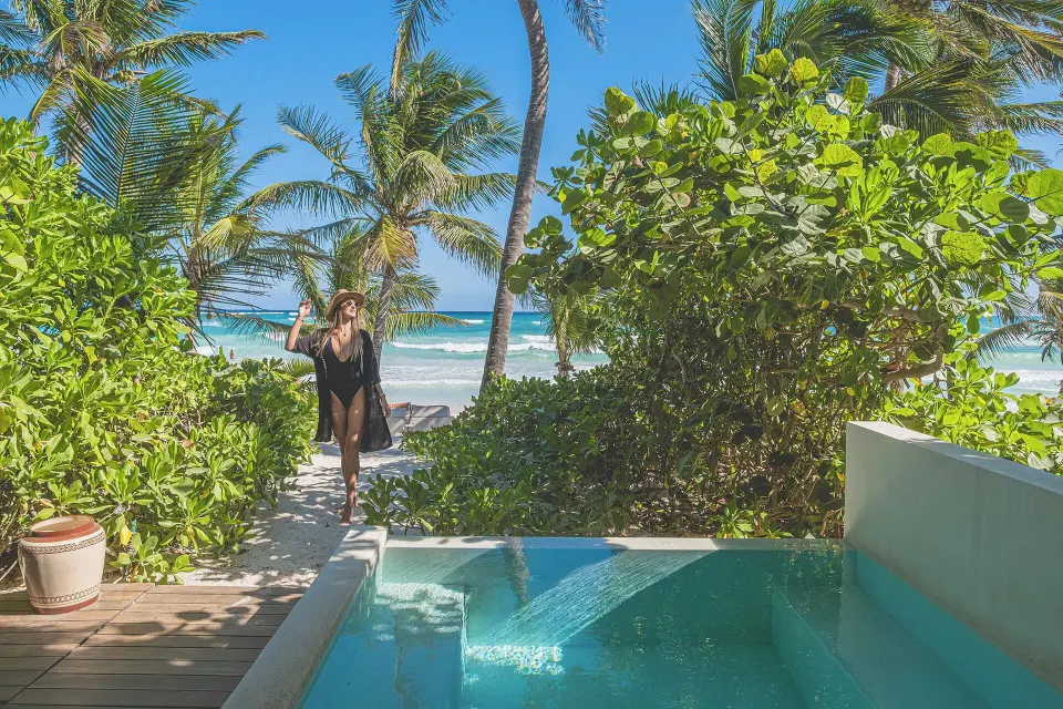 Plunge pool at a beachfront room with a guest walking toward the ocean at The Beach Tulum