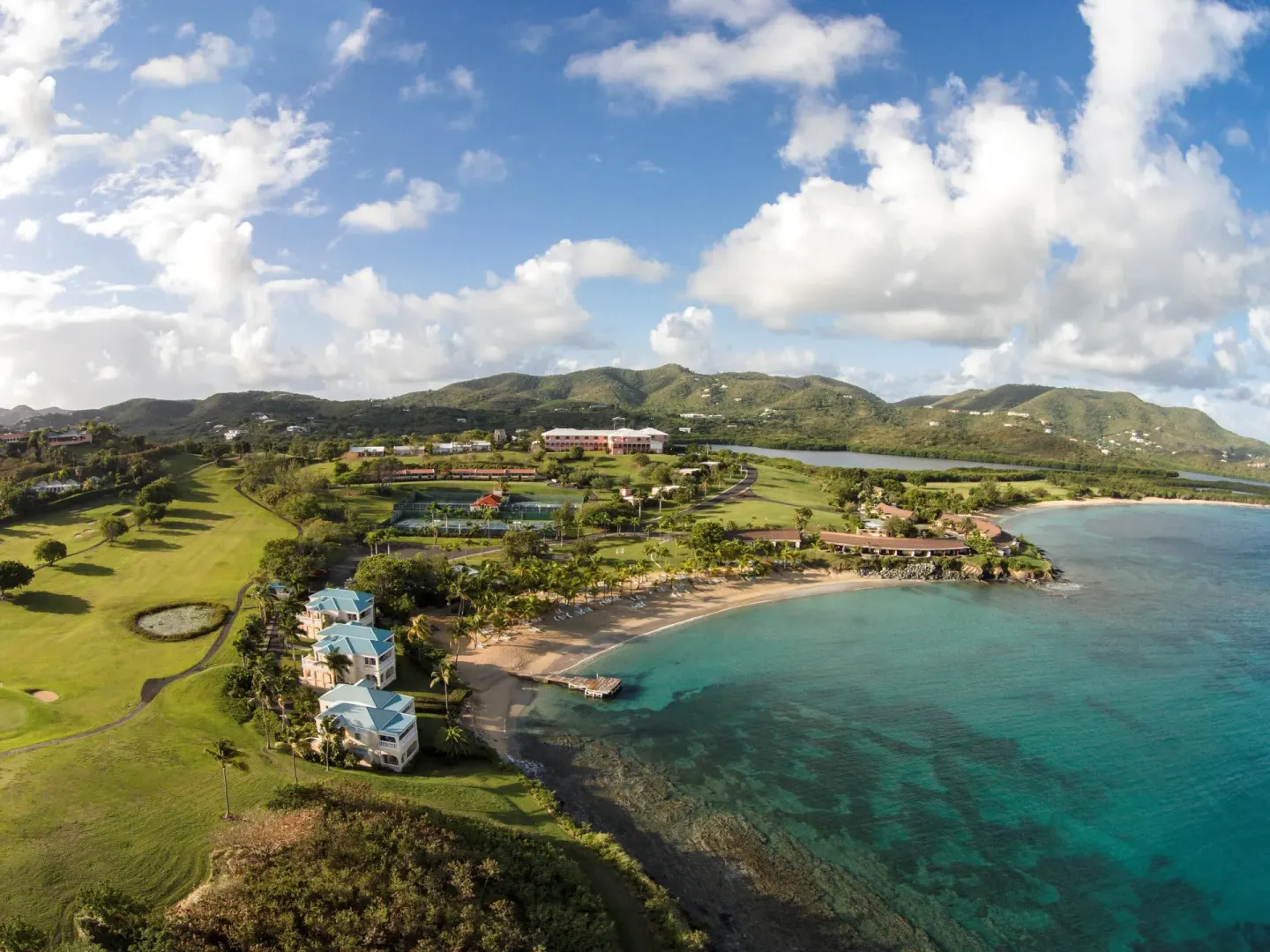 Aerial view of beaches, golf course, and coastline at The Buccaneer Beach & Golf Resort.