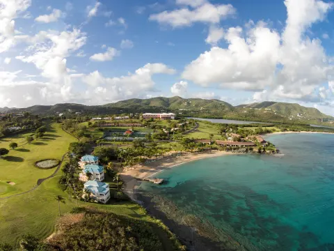 Aerial view of beaches, golf course, and coastline at The Buccaneer Beach & Golf Resort.