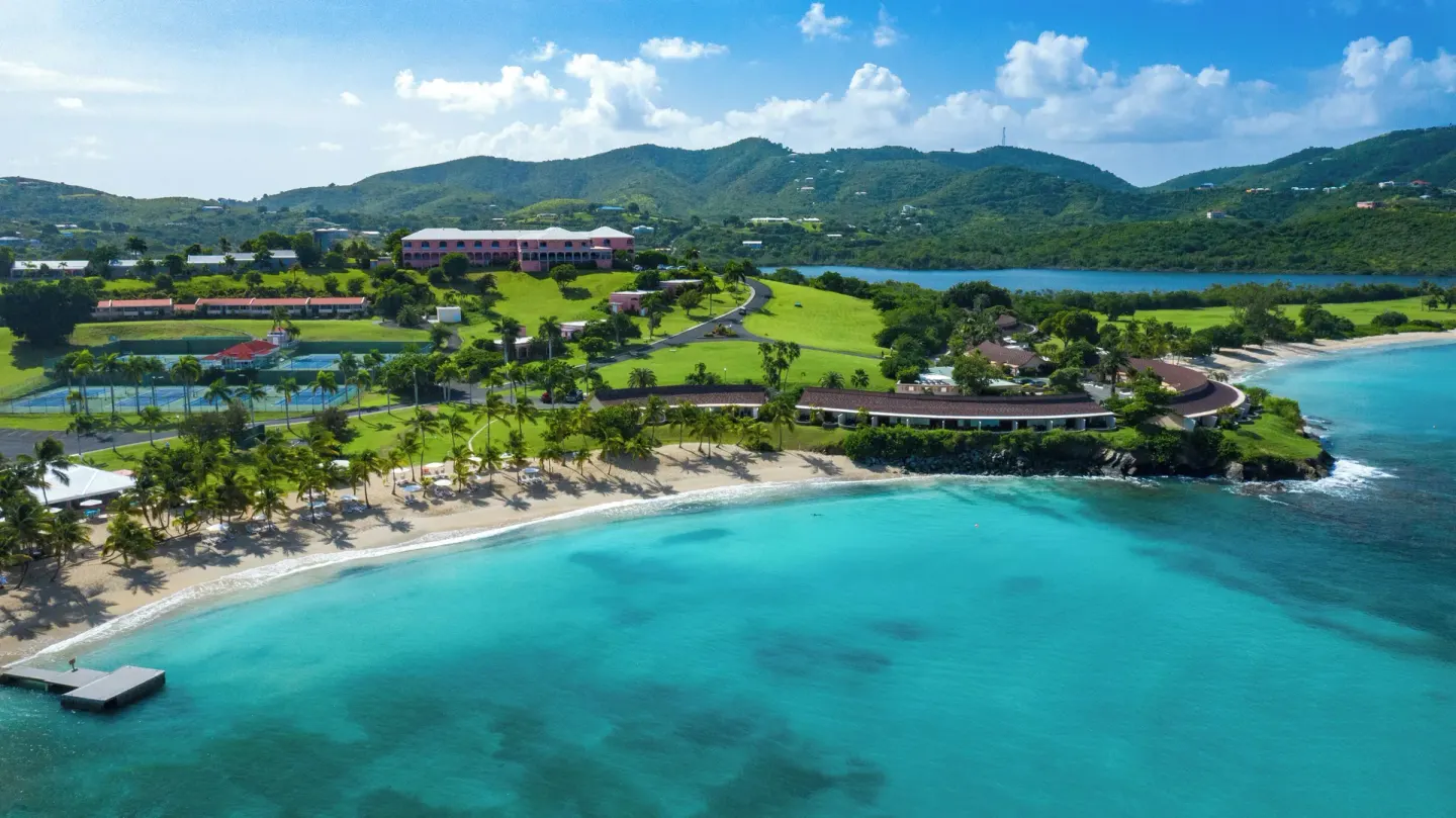 Aerial view of the beach and turquoise bay at The Buccaneer Beach & Golf Resort.