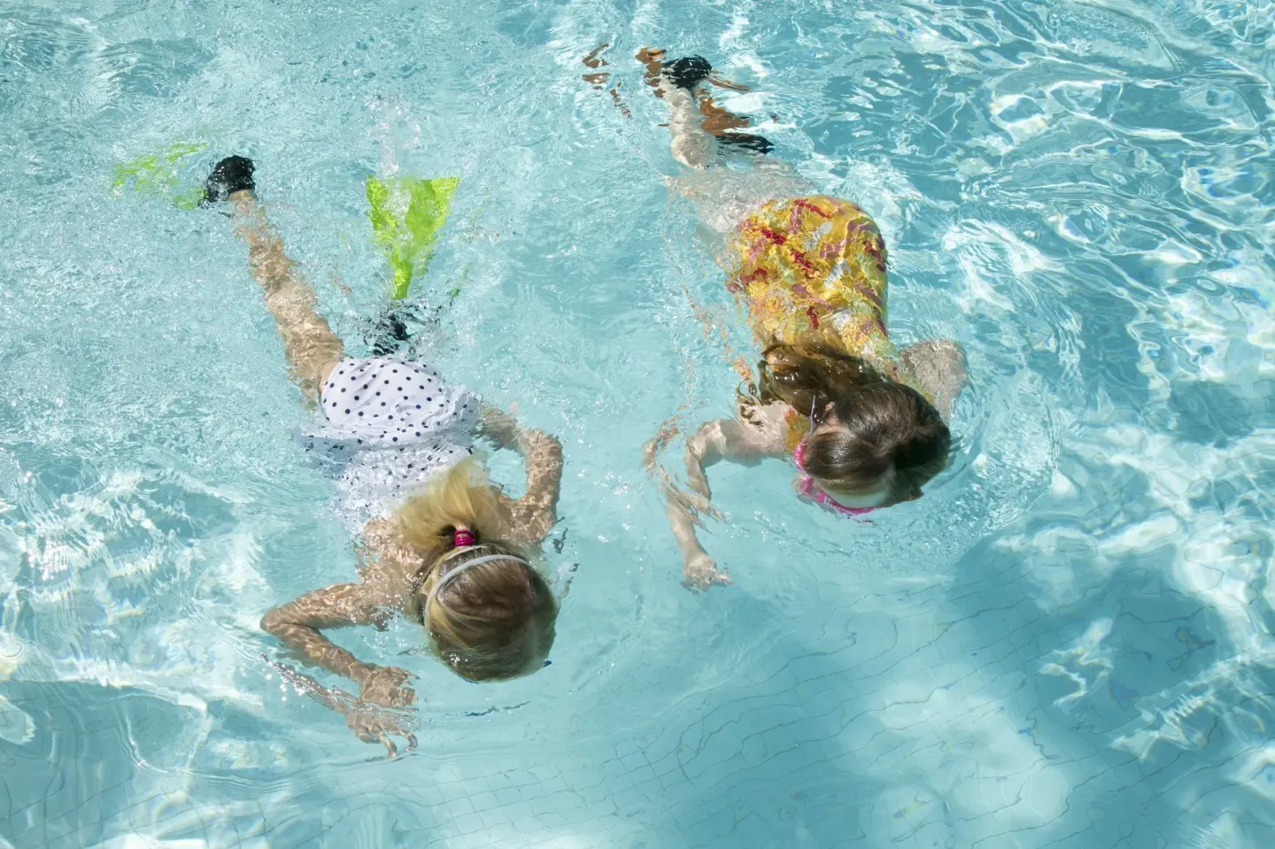Two children swimming underwater in a pool at The Buccaneer Beach & Golf Resort.