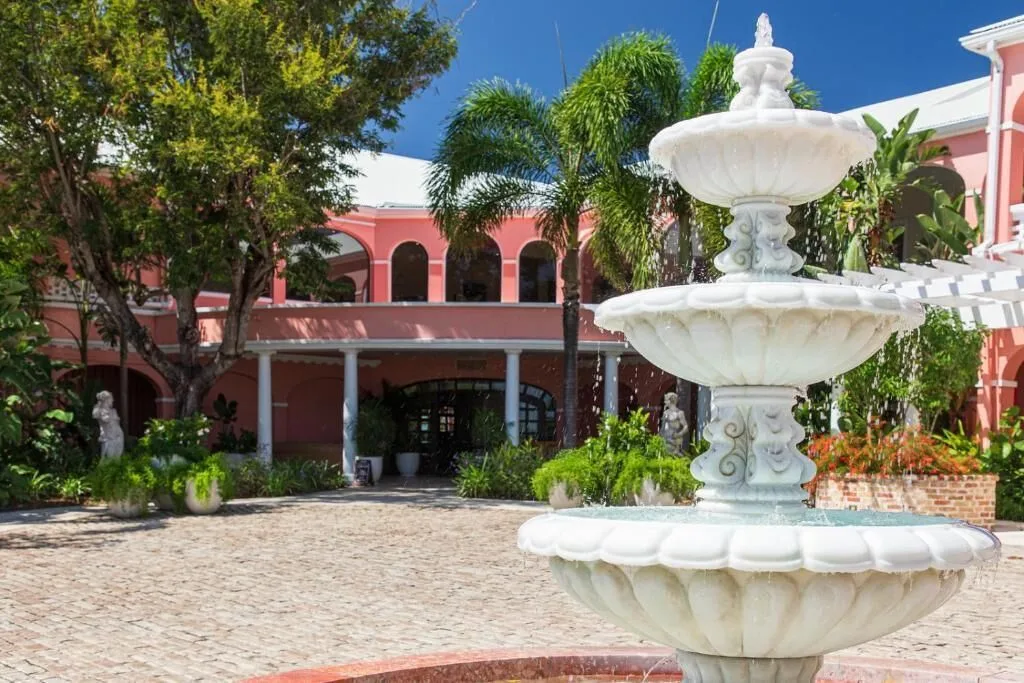 Courtyard fountain and pink resort building at The Buccaneer Beach & Golf Resort.