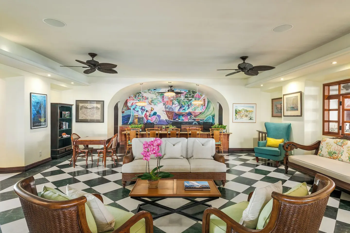 Lounge seating and a colorful mural in an indoor sitting area at The Buccaneer Beach & Golf Resort.