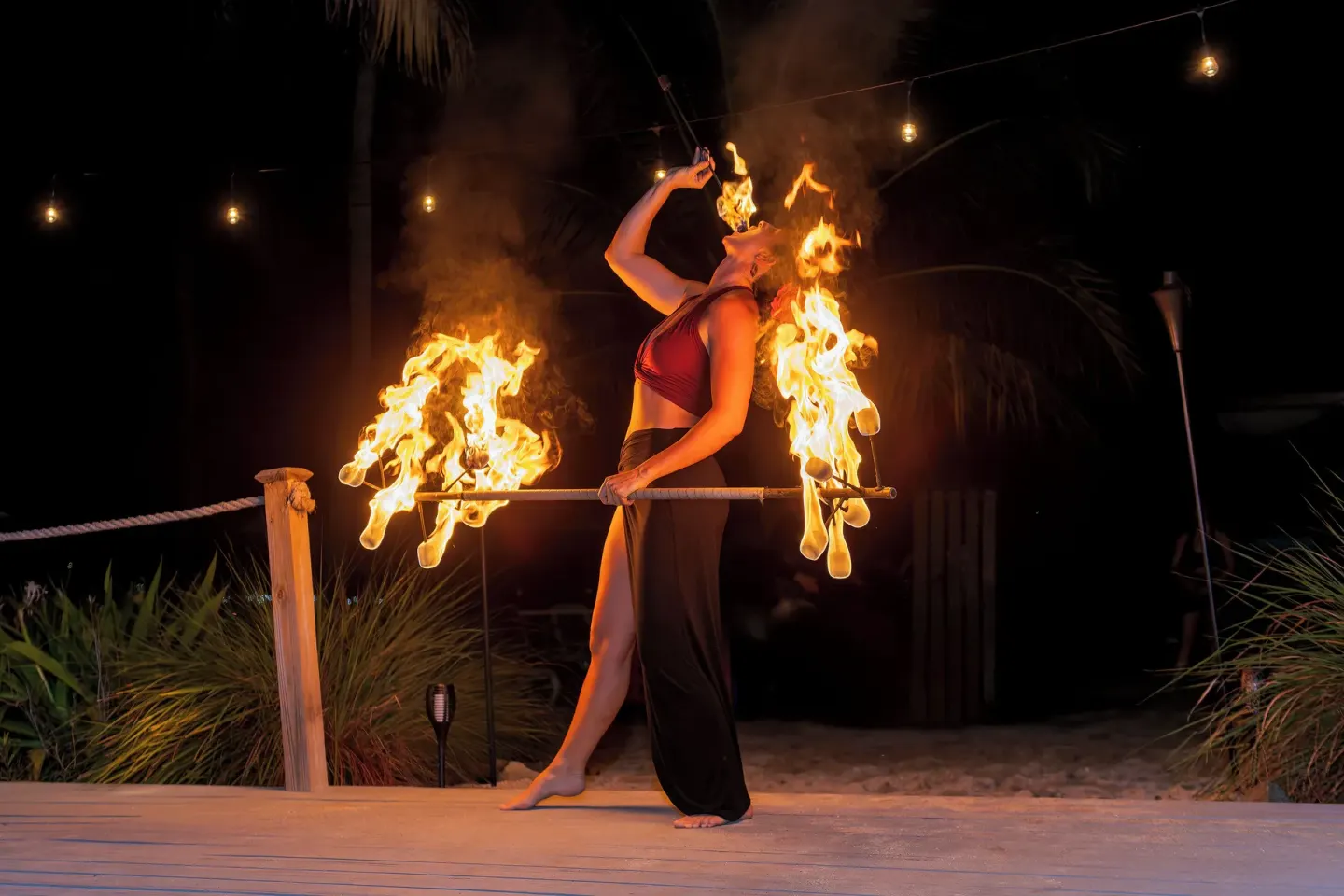 Fire performer on an outdoor stage at night at The Buccaneer Beach & Golf Resort.