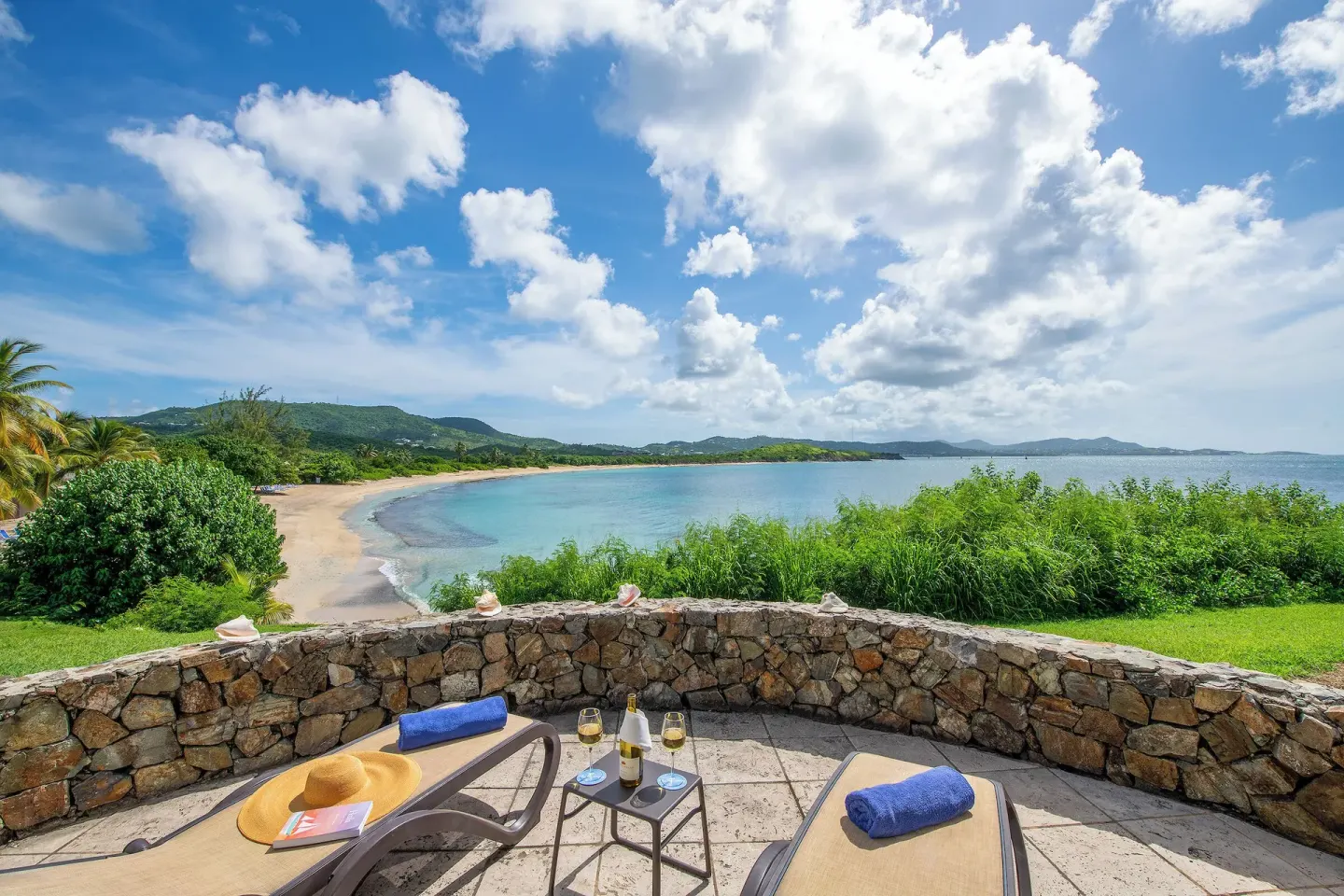Oceanfront patio with loungers and bay view at The Buccaneer Beach & Golf Resort.