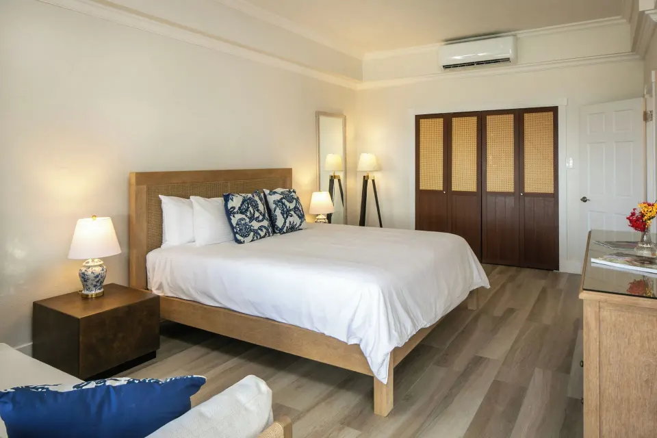 Family Cottage Suite king bedroom with wardrobe and dresser at The Buccaneer Beach & Golf Resort.