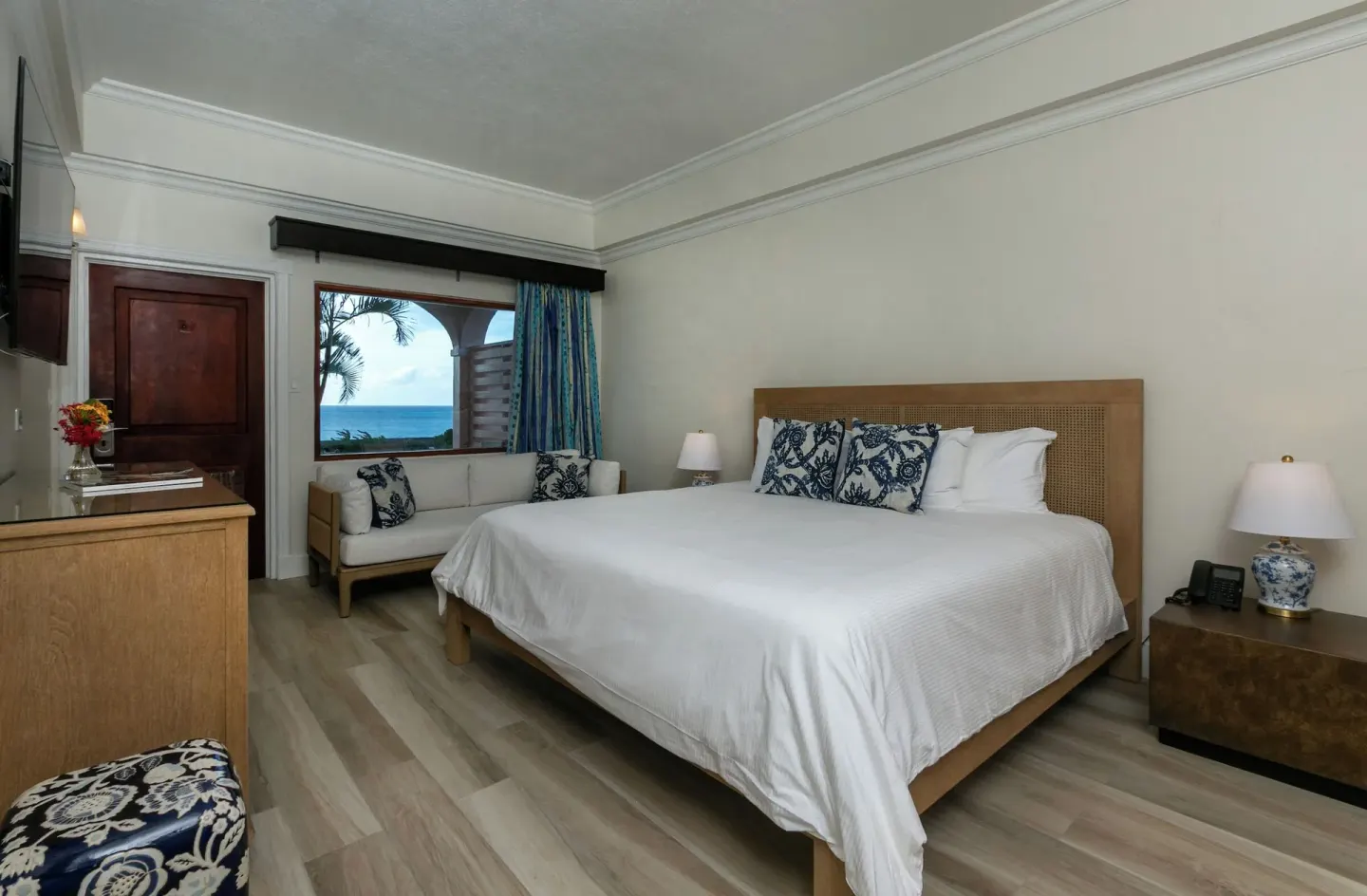 Family Cottage Suite king bedroom with ocean-facing window at The Buccaneer Beach & Golf Resort.
