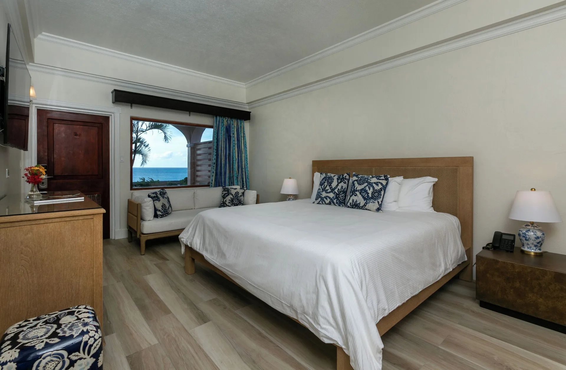 Family Cottage Suite king bedroom with ocean-facing window at The Buccaneer Beach & Golf Resort.