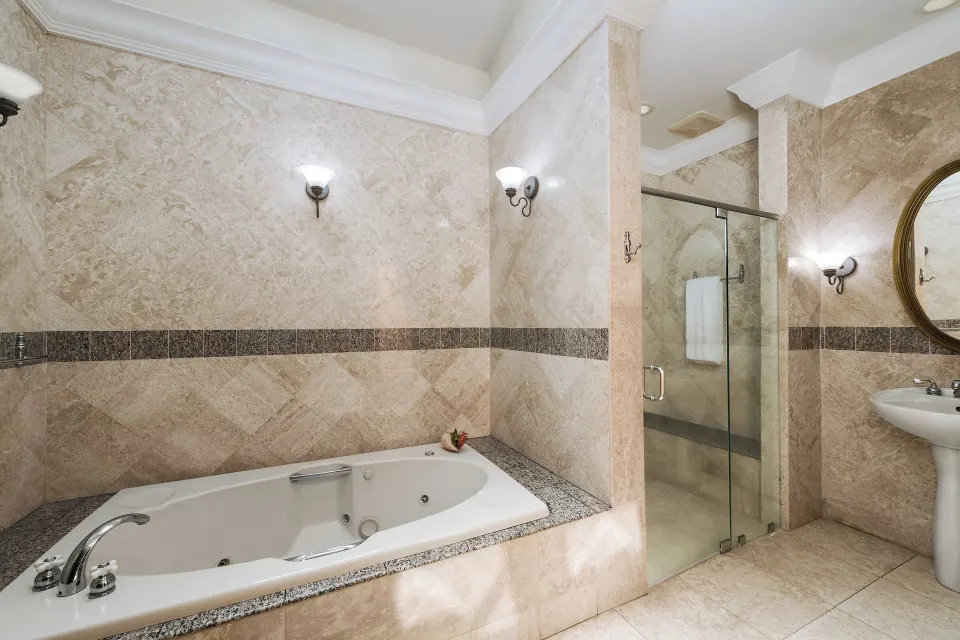 Luxury Room Beachside bathroom with tub and glass shower at The Buccaneer Beach & Golf Resort.
