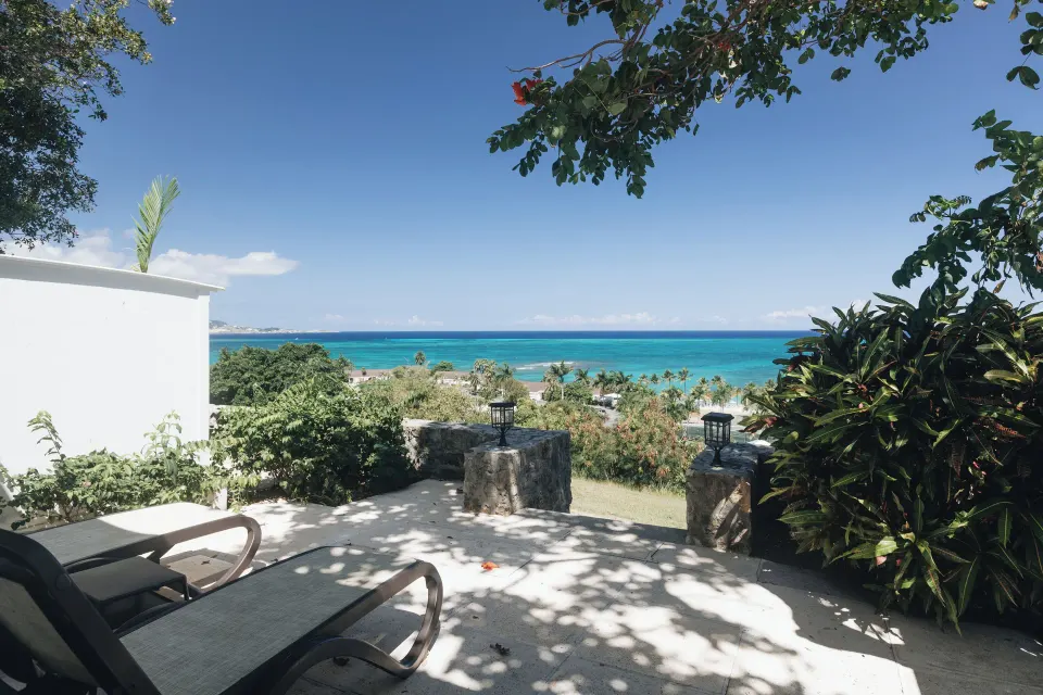 Private ocean-view terrace with lounge chairs at The Buccaneer Beach & Golf Resort.