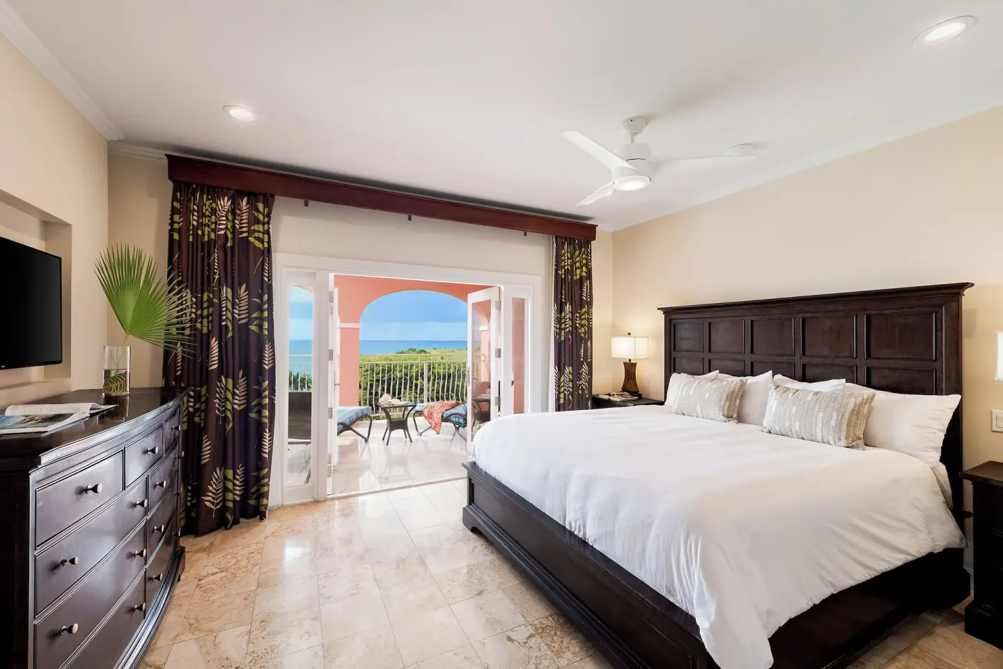 Great House Suite bedroom with king bed and ocean-view balcony at The Buccaneer Beach & Golf Resort.