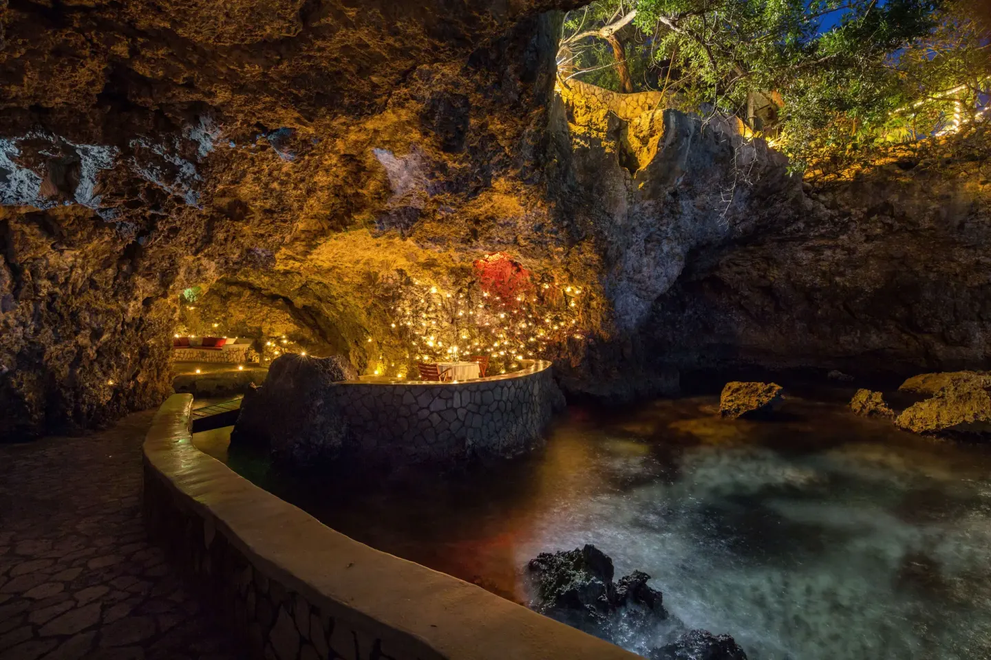 Cliffside cave terrace with lights above the water at The Caves.