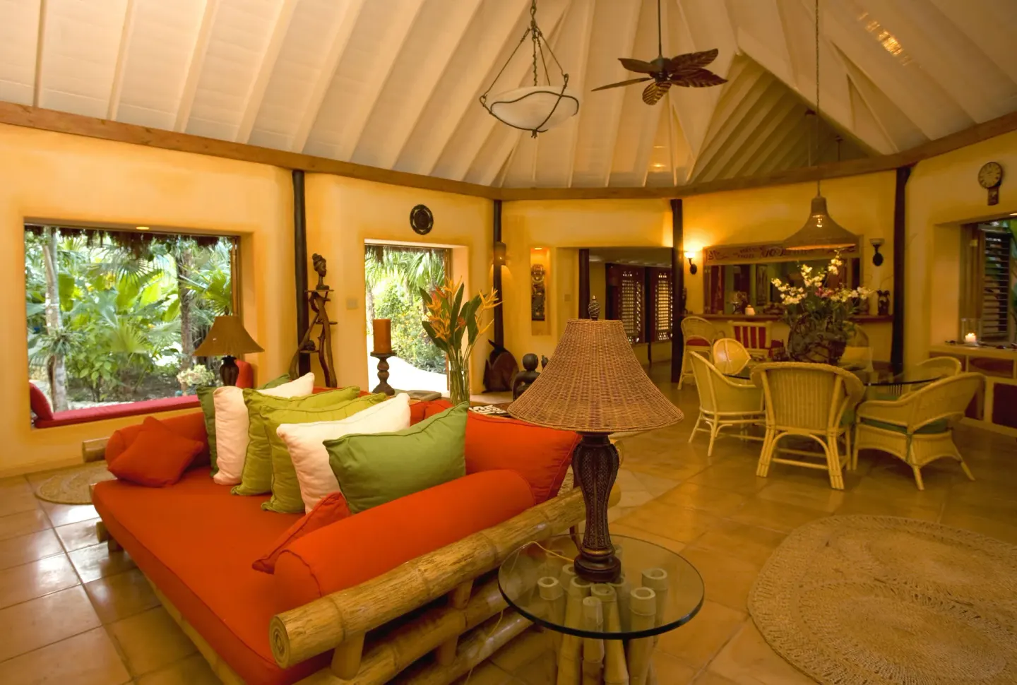 Colorful resort lounge with garden windows and wicker seating at The Caves.