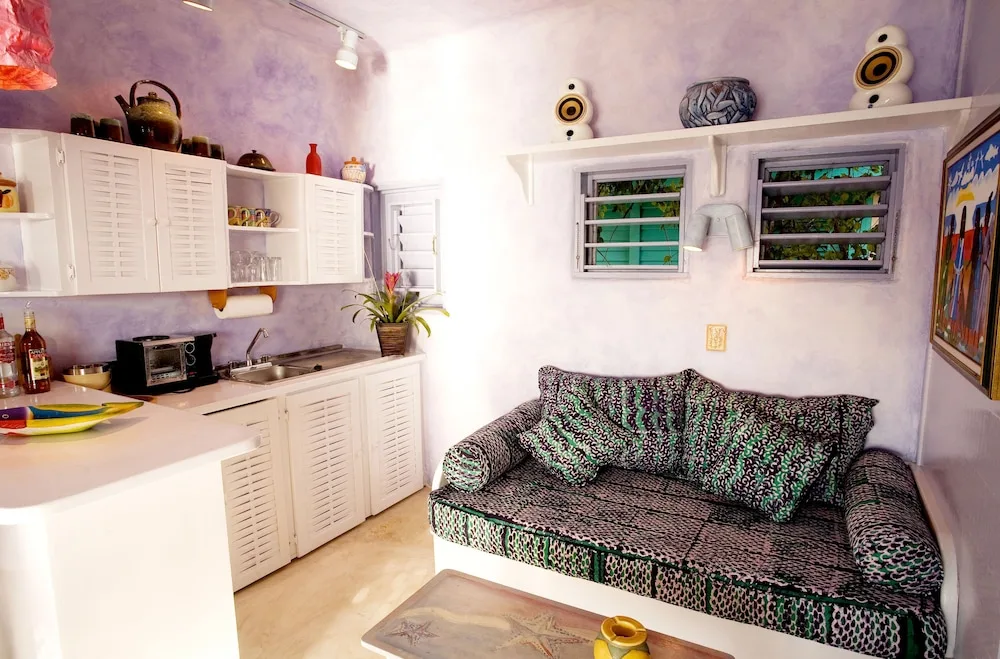 A compact sitting area with a sofa and kitchenette-style counter at The Caves.